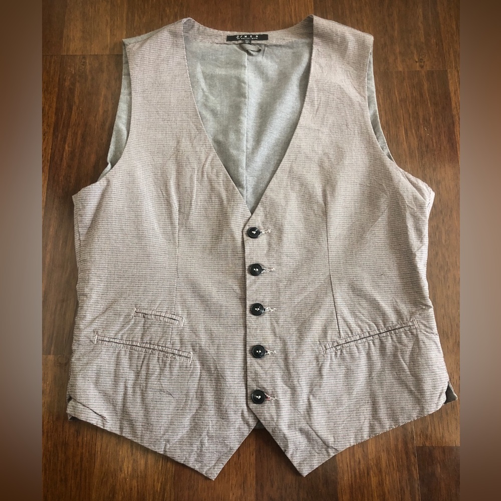 Elevate your outfit with this beige, blue. and red vest.